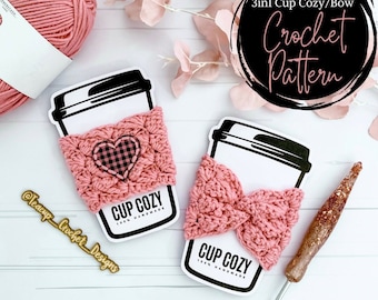 May include: Two pink crocheted cup cozies, one with a heart and the other with a bow. The cozies are on white cards with the text "CUP COZY 100% HANDMADE" and "Extended Waves 3in1 Cup Cozy/Bow Crochet Pattern".