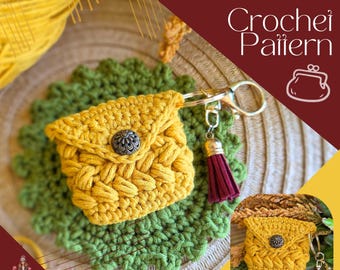 Puede incluir: Un monedero de ganchillo color amarillo mostaza con patrón de puntos texturizados, un botón decorativo de metal plateado y un llavero con una borla de ante color burdeos. El texto dice: TEENY TINY BEAN KEYRING/COIN PURSE Crochet Pattern.