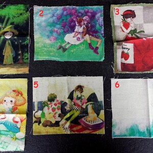 Könnte beinhalten: Sechs Stoffquadrate mit verschiedenen Illustrationen. Die Designs umfassen eine Hexe und eine Katze in einem Wald, ein Paar in einem Garten, ein Mädchen mit einer Erdbeere und andere skurrile Szenen. Die Quadrate sind auf einer dunklen Oberfläche angeordnet.