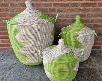 May include: Three woven storage baskets with lids in different sizes. The baskets are green and white with a geometric pattern.