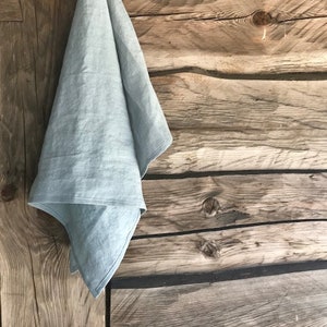 May include: A light blue linen tea towel hanging on a wooden wall.
