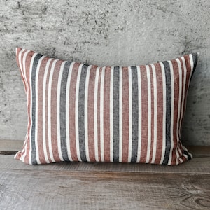 May include: A red, white, and black striped throw pillow with a linen texture.