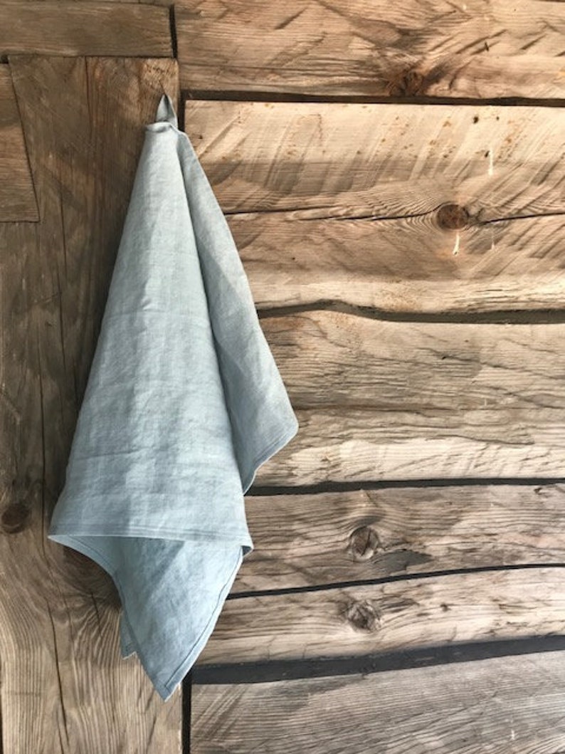 May include: A light blue linen tea towel hanging on a wooden wall.