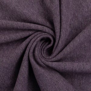 May include: Close-up of a soft, purple fabric with a textured, knitted surface. The fabric is folded and twisted, creating a swirling pattern.