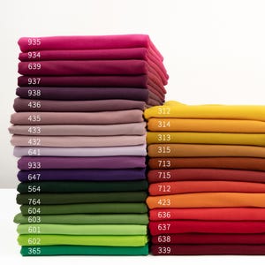 Peut inclure: Un assortiment d'échantillons de tissu de différentes couleurs, dont le rouge, l'orange, le jaune, le vert, le bleu, le violet et le marron. Chaque échantillon porte un numéro imprimé.