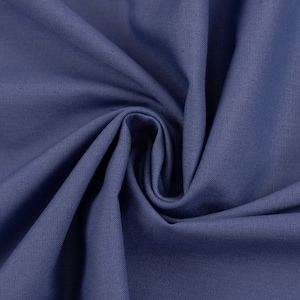 Op de afbeelding: Close-up van een blauwe stof met een textuurweefsel. De stof is gevouwen en gedrapeerd, waardoor de zachte textuur zichtbaar wordt.