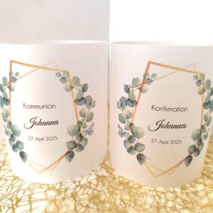 Könnte beinhalten: Zwei weiße Kerzenhalter mit goldenen geometrischen Rahmen und grünen Eukalyptusblättern. Der Text auf dem linken Kerzenhalter lautet "Kommunion Johanna 27. April 2025". Der Text auf dem rechten Kerzenhalter lautet "Konfirmation Johannes 27. April 2025".