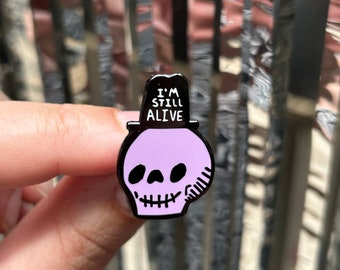 Purple I'm Still Alive Ultimate Self Help Mantra Happy Spooky Skull Enamel Pin Badge