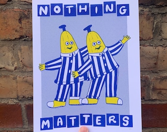 May include: A blue and white print with two yellow banana characters wearing blue and white striped pajamas. The text "NOTHING MATTERS" is printed in blue letters on the print.
