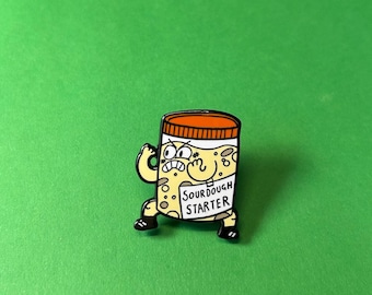 May include: A yellow and brown cartoon sourdough starter jar with a black outline and a white label that says "SOURDOUGH STARTER". The jar has a red lid and is wearing black shoes and a black arm band. The jar has a surprised expression with its eyes wide open and its mouth open.