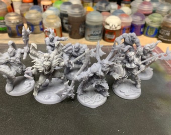 May include: A group of seven gray plastic miniature figures of orcs, each holding a weapon, standing on round bases.