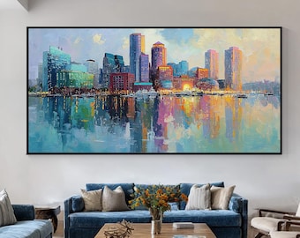 Pode incluir: Grande pintura emoldurada de uma paisagem urbana com uma paleta de cores vibrantes. A obra retrata um horizonte com edifícios coloridos refletidos na água. A pintura é exibida numa sala de estar moderna com sofás azuis e uma poltrona amarela.