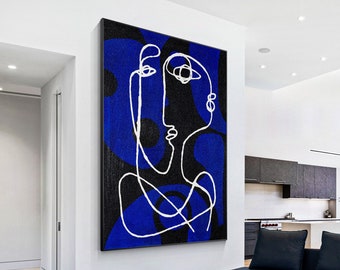 May include: A large rectangular wall art piece featuring a bold abstract face rendered in a single continuous white line. The background consists of deep blue and black textured shapes, creating a high-contrast composition on a vertical canvas.