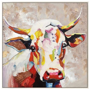 May include: A colorful abstract painting of a cow's head. The cow is white with splashes of red, yellow, green, blue, and purple paint. The background is a muted gray with hints of gold.
