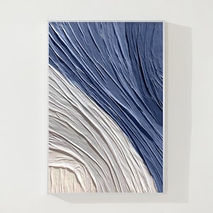 K&ouml;nnte beinhalten: Abstrakter Kunstdruck mit einem strukturierten Design in Blau und Wei&szlig;. Das Design &auml;hnelt zerknittertem Stoff mit einer diagonalen Linie, die die beiden Farben trennt.