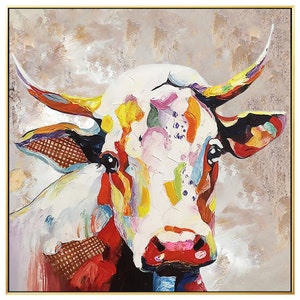 May include: A colorful abstract painting of a cow's head. The cow is white with splashes of red, yellow, green, blue, and purple paint. The background is a muted gray with hints of gold.