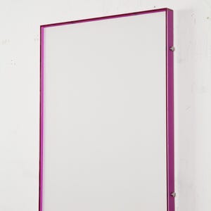 May include: A rectangular wall-mounted display frame featuring a solid white center panel enclosed by a vibrant, translucent magenta acrylic border. The frame is secured with small silver-toned metal hardware on the right side edge.