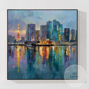 以下が含まれることがあります： 夕暮れ時の都市景観を描いた油絵。水面に映る高層ビルが特徴です。青、オレンジ、紫の色使いで、左側に塔があります。絵は黒いフレームに入っています。作品にはサインが入っています。