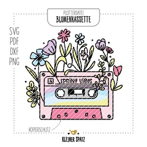 May include: A pink cassette tape with the text "Spring Vibes" on it. The tape is surrounded by colorful flowers.