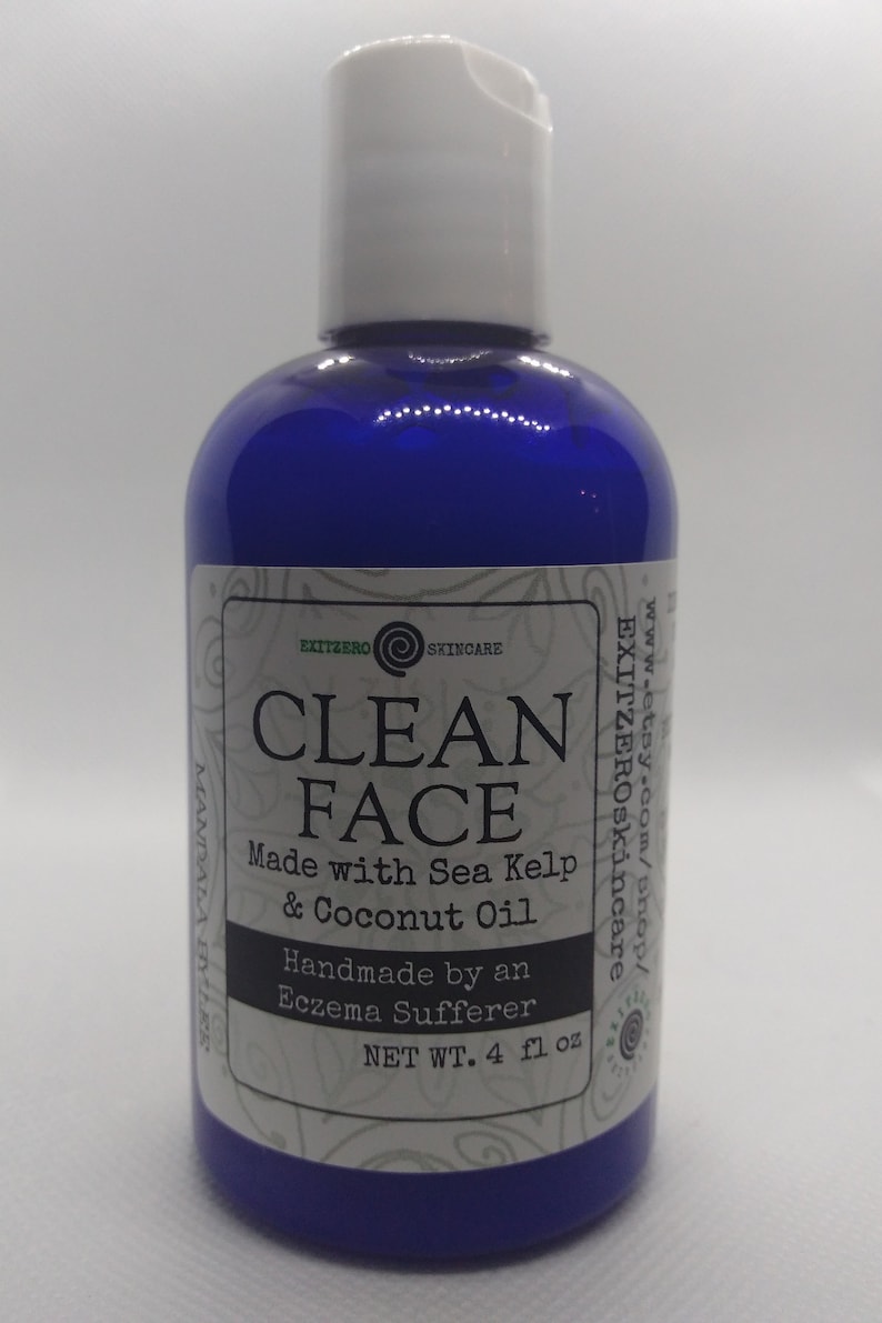 May include: A blue plastic bottle with a white label that reads "CLEAN FACE" and "Made with Sea Kelp & Coconut Oil". The label also says "Handmade by an Eczema Sufferer" and "NET WT. 4 fl oz".