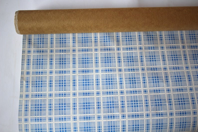 K&ouml;nnte beinhalten: Eine Rolle blaues und wei&szlig;es kariertes Geschenkpapier mit einem braunen Pappkern.