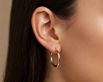 Puede incluir: Pendientes de aro de oro usados en el lóbulo de la oreja.