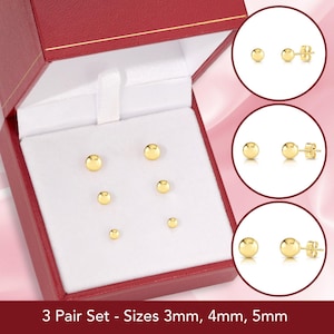 May include: A set of three pairs of gold stud earrings in a red box. The earrings are 3mm, 4mm, and 5mm in size. 3 Pair Set - Sizes 3mm, 4mm, 5mm