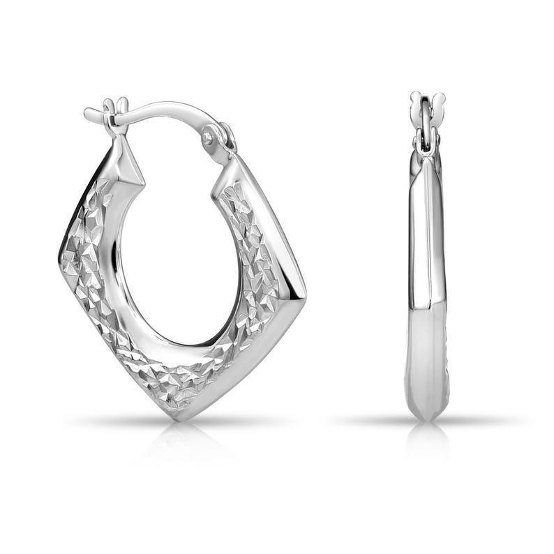 May include: A pair of silver hoop earrings featuring a distinct diamond-shaped silhouette. The front-facing earring displays a textured, faceted surface that catches the light, while the side-facing earring shows a smooth, polished metallic finish.