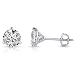 Puede incluir: Un par de pendientes de diamantes. Cada pendiente presenta un diamante redondo con talla brillante engastado en una montura de tres puntas. Los postes y engastes son de metal brillante color plata, probablemente platino u oro blanco.