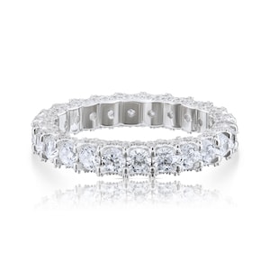 May include: A silver eternity band with a row of round, clear cubic zirconia stones.