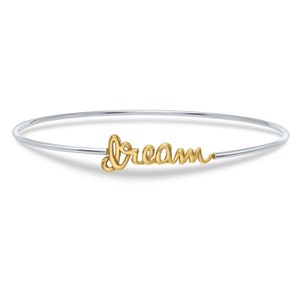 May include: A silver bangle bracelet with a gold charm that says "dream".