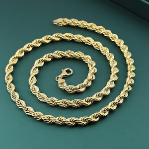 May include: A gold rope chain necklace with a clasp closure. The chain is made of thick, twisted links.