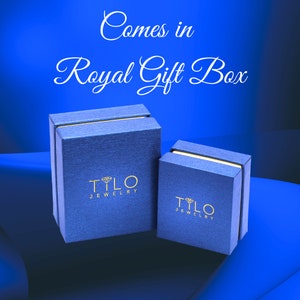 May include: Two blue gift boxes with gold lettering that reads "Tylo Jewelry". The boxes are on a blue background with the text "Comes in Royal Gift Box" above them.
