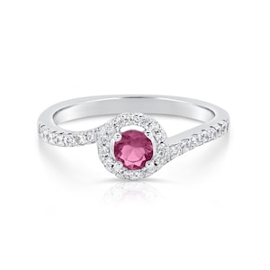 May include: A silver ring with a pink gemstone surrounded by a halo of smaller white gemstones. The band is twisted and has a row of smaller white gemstones.
