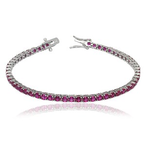 May include: A silver tennis bracelet with a row of oval-cut, vibrant pink gemstones. The bracelet is open, showing the clasp and the gemstones are set closely together. The bracelet is displayed on a white background.