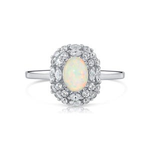 May include: A silver-toned ring featuring a central oval-shaped opal gemstone with iridescent flashes of color. The opal is surrounded by a cluster of small, clear, round and marquise-cut stones set in a halo arrangement on a polished metal band.