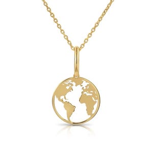 Puede incluir: Un collar dorado con un colgante en forma de mapa del mundo. El colgante es un contorno circular de los continentes. La cadena y el colgante son de metal brillante y reflectante.