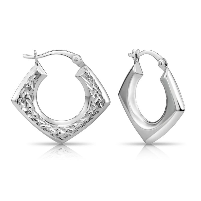 May include: A pair of silver-toned hoop earrings featuring a distinct diamond-shaped silhouette. One earring displays a textured, faceted surface that catches the light, while the other earring has a smooth, polished finish with a hinged clasp closure.