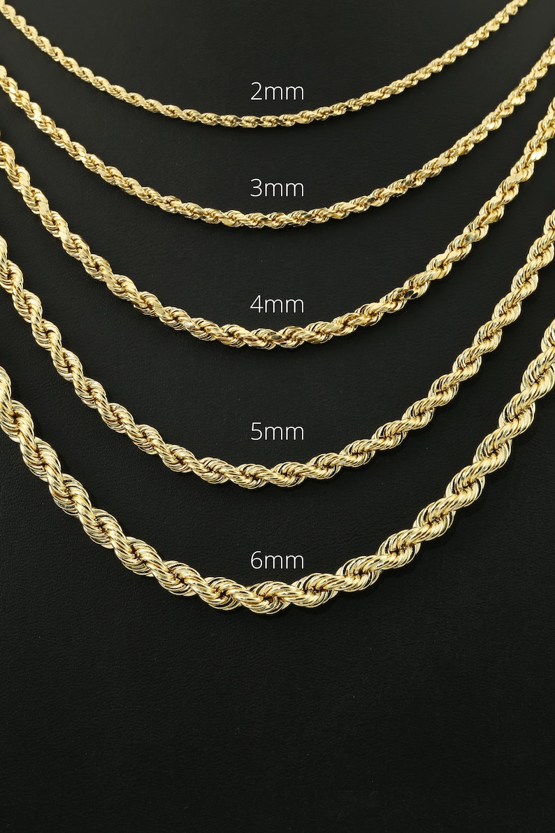 May include: Five gold rope chains of different thicknesses, laid out on a black surface. The chains are labeled with their thickness in millimeters: 2mm, 3mm, 4mm, 5mm, and 6mm.