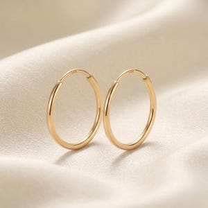 Pendientes de aro redondos sin fin de oro amarillo de 14 quilates, aros delicados e imprescindibles para el día a día, 1,3 mm de grosor, de TILO Jewelry.