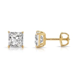 May include: A pair of square-cut diamond stud earrings set in yellow gold. The diamonds are clear and sparkling, and the earrings have a classic, elegant design. The earrings are shown on a white background.