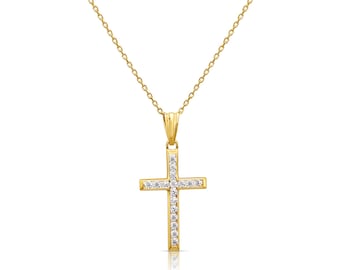 Könnte beinhalten: Eine goldene Kreuz-Halskette mit einer feinen Kette und einem Kreuzanhänger, der entlang der vertikalen und horizontalen Balken mit kleinen, klaren, funkelnden Steinen besetzt ist, befestigt an einer schlichten goldenen Öse.