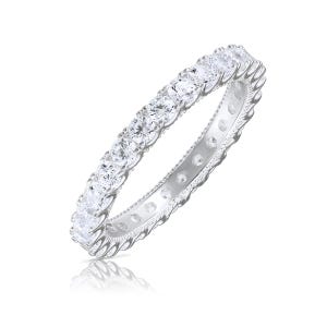 May include: A silver eternity band with a row of round, clear cubic zirconia stones.