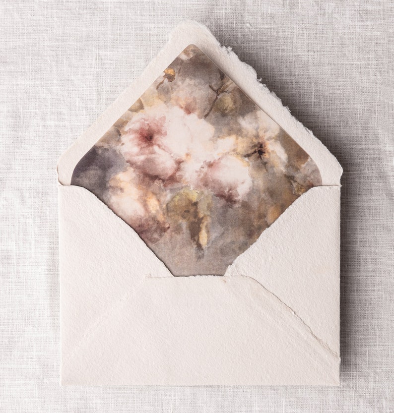 May include: A white envelope with a floral design on the front. The design features a watercolor painting of pink and brown flowers.