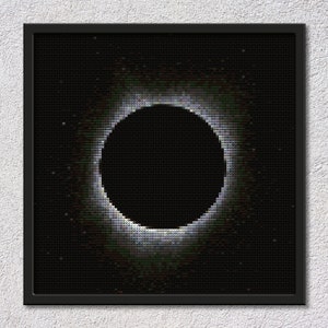 Könnte beinhalten: Ein pixeliertes Schwarzweißbild einer Sonnenfinsternis. Die Sonne ist ein heller weißer Ring mit einem schwarzen Kreis in der Mitte.