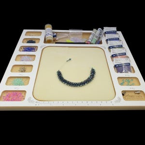 Low profile view of the Acclaim Crafts Seed Beaders Dream Board in use, filled with beads, supplies, and a finished bracelet.