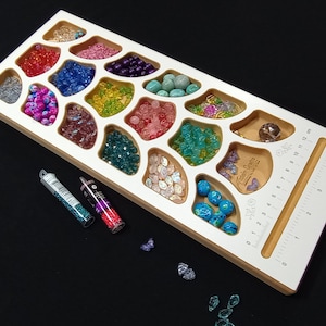 Acclaim Crafts Bead Stringers Pocket Board with various colorful beads, the deep pockets keep supplies separated yet accessible.