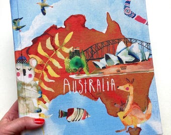 May include: A square book with a colorful illustration of Australia. The cover features a map of Australia in shades of red and brown, with the word "AUSTRALIA" in white. The image includes a kangaroo, koala, and Sydney Opera House.