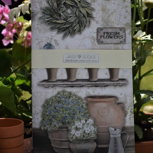 Könnte beinhalten: Eine Karte im Vintage-Stil mit einem Blumenkranz, Topfpflanzen und einem Schild mit der Aufschrift "Fresh Flowers". Die Karte enthält auch den Text "JKEE BOOKS handmade made with love".