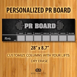 May include: Black and white dry erase board with the text "PR BOARD" and a weightlifting icon. The board has columns for "Squat", "Bench", "Deadlift", "PWR CLN", "O.H. Press", "Snatch", and "1 MI. RUN". The board is 28 inches by 8.7 inches.